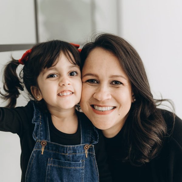 Suélen abrazada a su hija Luísa, de 3 años, las dos sonriendo
